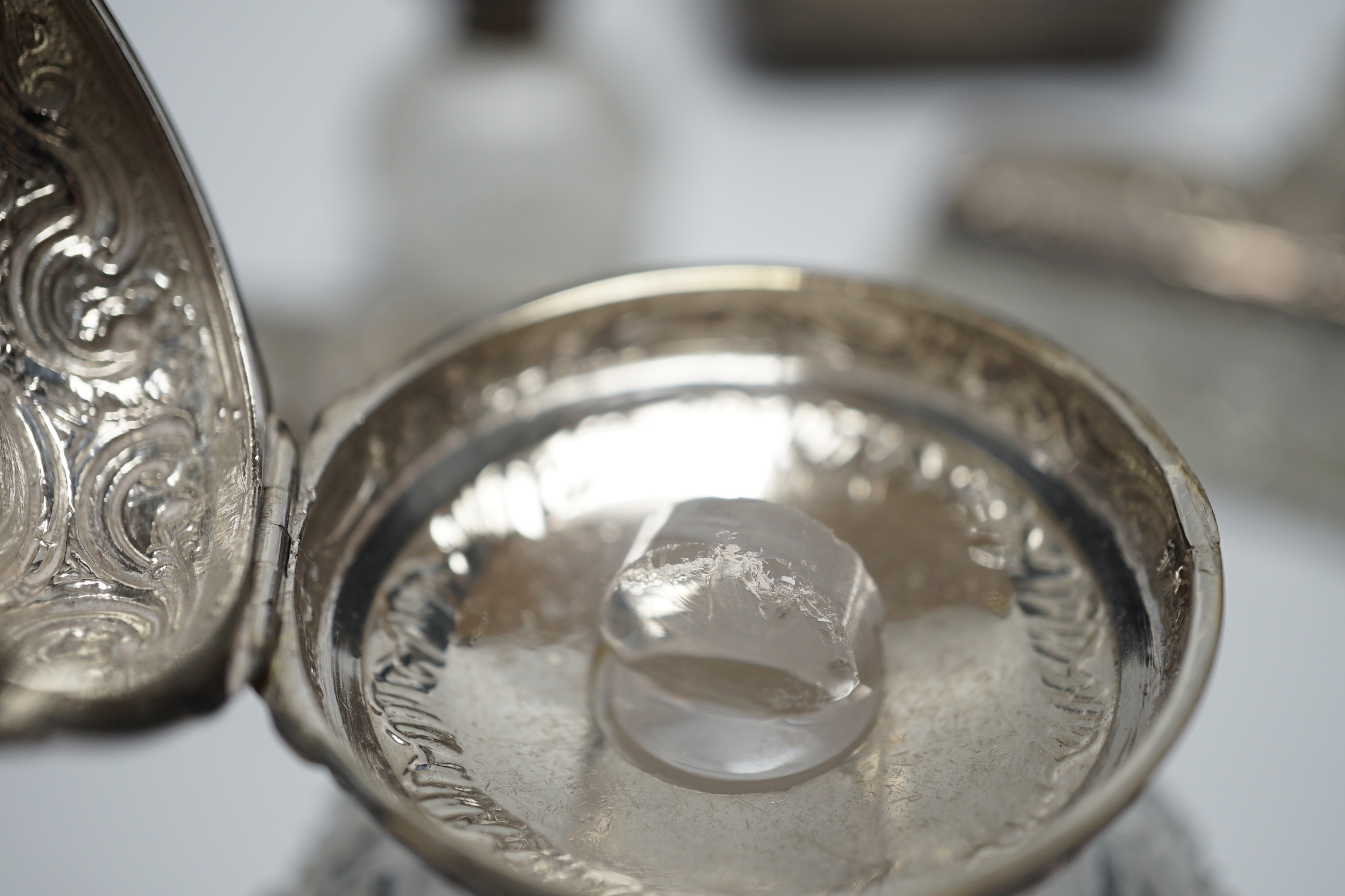 A late Victorian repousse silver mounted travelling pocket watch case, Birmingham, 1898, 11.6cm, with nickel cased pocket watch, together with five silver topped glass toilet jars.